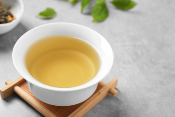 Cup of green tea on grey table