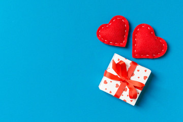 Top view of gift boxes and red textile hearts on colorful background. St Valentine's day concept with copy space
