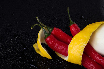 Capsicum annuum and lemon zest close up. Scarlet pepper and yellow citrus tandem. Food concept.