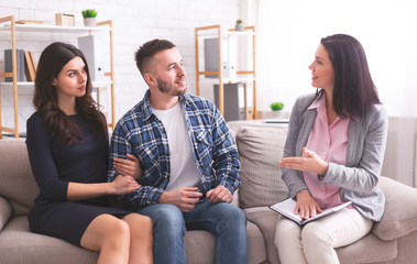 Millennial spouses talking with psychotherapist at office - obrazy, fototapety, plakaty