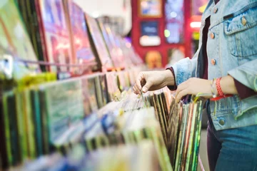 Wall murals Young Woman Choosing Vintage Vinyl LP In Records Shop