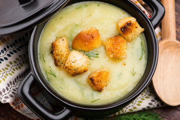 Creamy Jerusalem artichoke soup on wooden background