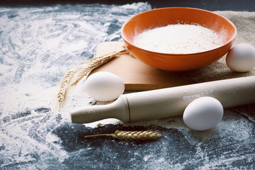 flour and eggs on wooden table. Process of baking