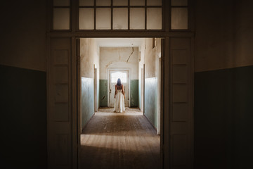 beautiful bride back with white vintage wedding dress in old abandoned manor house
