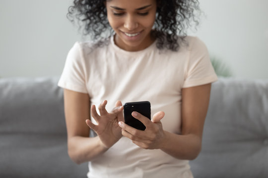 African woman holding smartphone closeup focus on hands and gadget
