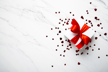 White gifts with red ribbon, present on white marble background top view. Happy Holidays. Valentine's day. Birthday. Women's day.	