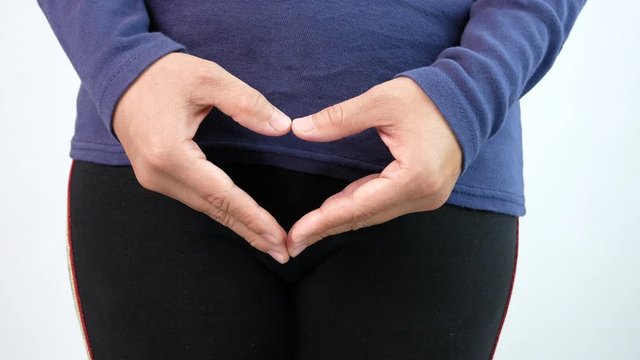 Asian woman making heart shape by hands on the crotch, isolated on white background. Hygiene and Healthcare concept.