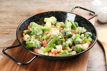 Tasty frozen vegetable mix on wooden table, closeup