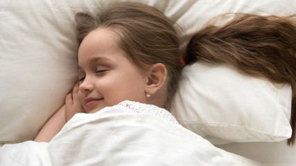 Calm adorable child, little preschool girl sleeping in comfortable bed
