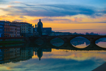 Florence, Ponte alla Carraia medieval Bridge landmark on Arno river at sunset. Tuscany, Italy.