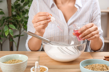 Woman making natural handmade soap at wooden table, closeup