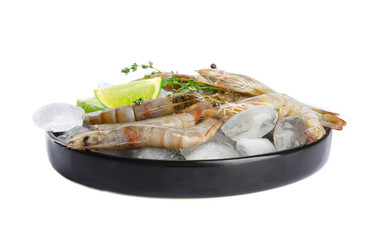 Plate with raw shrimps, lime slices, thyme and ice isolated on white