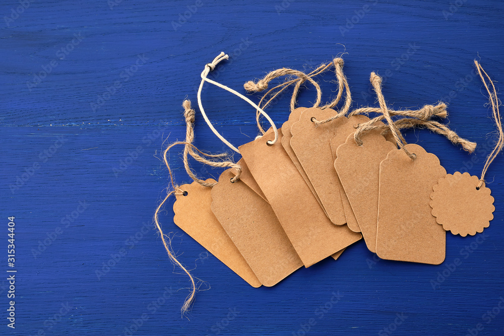 Poster stack of empty brown empty tags from kraft paper with ropes for clothes and other purposes