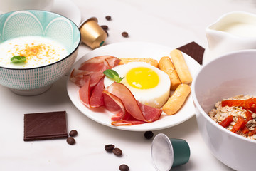breakfast of oatmeal, milk, coffee, fried eggs close-up