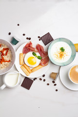 breakfast of oatmeal, milk, coffee, fried eggs