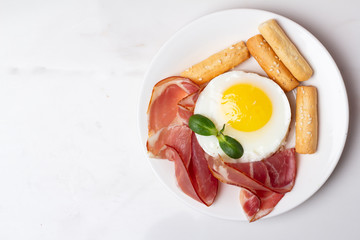 fried eggs with meat and bread on a white background