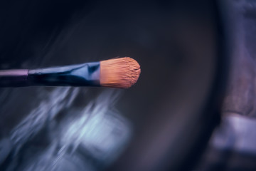 Makeup brush with an abstract backround.Professional eyeshadow brush closeup.