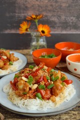 Cauliflower Kung Pao with bell pepper and rice noodles. Garnish with peanuts, scallions and sesame seeds. Vegan food