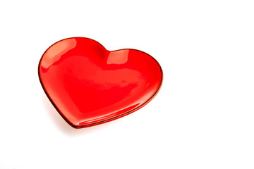 A red heart shape plate isolated on white background. Decoration for Valentine's day, wedding, birthday of any other love celebration.