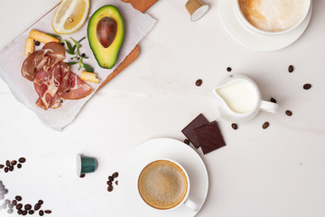 breakfast concept: coffee, milk, avocado, bacon, porridge, chocolate and place for text