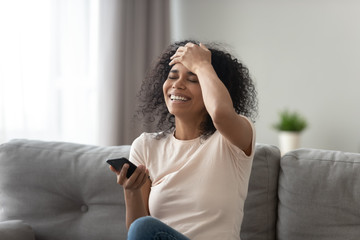 African woman laughs at funny video or joke prank online