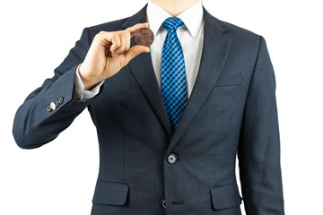 A person wearing a suit and holding a bitcoin in his hand.