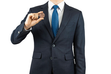 A person wearing a suit and holding a bitcoin in his hand.