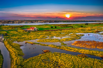 Bull Island aerial view at sunset, revealing marram-grass-anchored dunes and Dublin city on the...