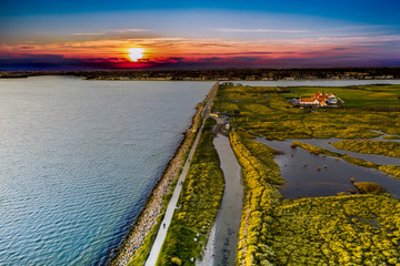 Bull Island aerial view at sunset, revealing marram-grass-anchored dunes and Dublin city on the horizon. North Bull Island, is an island located in Dublin Bay. Autumn view with flooded dunes.