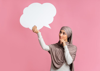 Empty speech bubble in hands of thoughful islamic girl in hijab