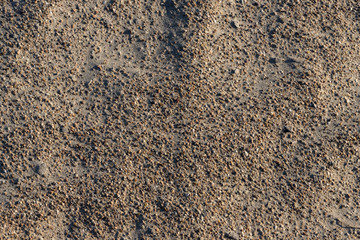 Graphic sand texture with very large grains of sand. The shore of the reservoir.