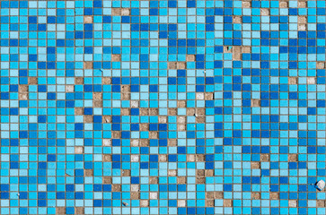 Damaged surface with blue square tile mosaic. Broken surface with missing pieces of tiles.