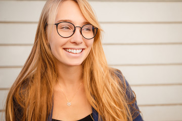 Close-up portrait of blonde girl in glasses. Beautiful student.