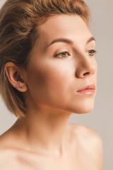 Naklejka premium beautiful girl with fair skin and green eyes. Face close up. Studio picture