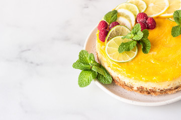 Lemon mousse vanilla cheesecake with lemon curd decorated by lemon and lime slices, frozen...
