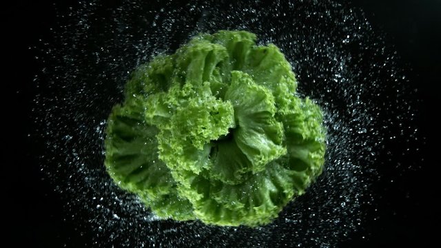 Super slow motion of rotating fresh salad with water drops. Filmed on high speed cinema camera, 1000 fps.