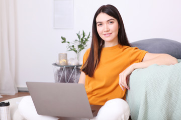 Obraz na płótnie Canvas girl works at a laptop at home