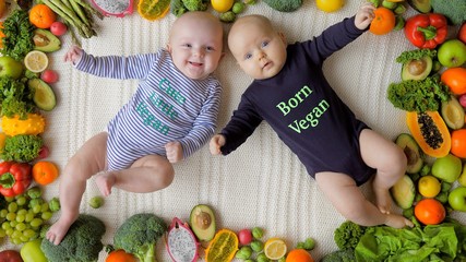 Fototapeta na wymiar Healthy Babies Born Vegan Lying Together In Organic Fresh Vegetables And Fruits.