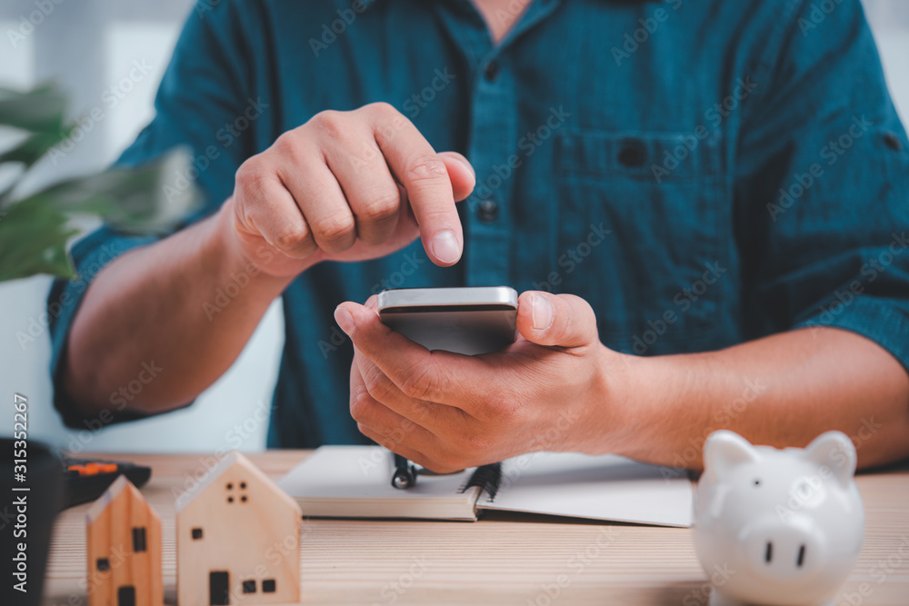 Poster close up of man hands using mobile smartphone at home, he searching for investment finance concept.