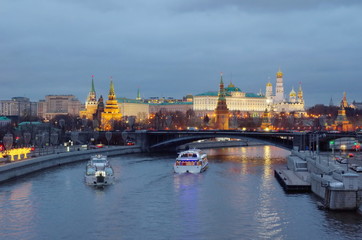 Evening view of the Moscow Kremlin, the Big Stone bridge and pleasure boats sailing along the Moscow-river. Moscow, Russia