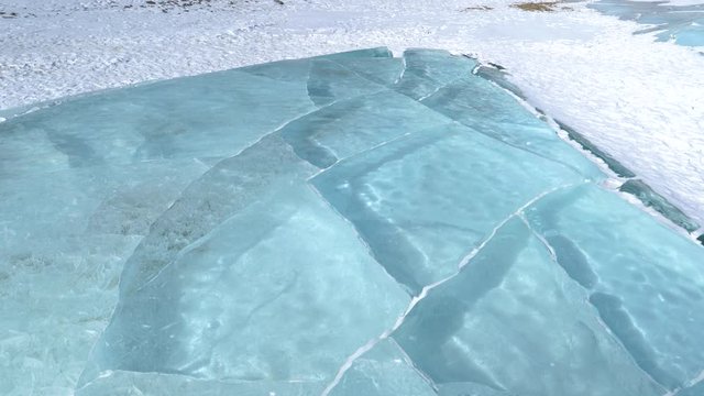 CLOSE UP: Beautiful shot of frozen crystal clear Lake Abraham in the scenic Banff National Park. Stunning turquoise water of Lake Abraham freezes in the winter cold high in the Canadian Rockies.