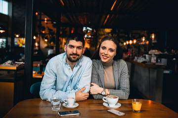 happy couple drinking coffee in cafeteria