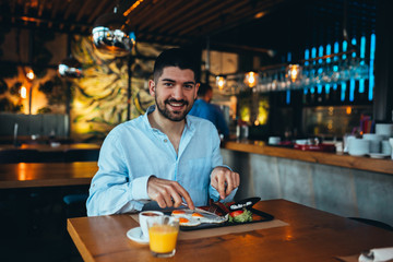 young woman having breakfast in restaurant