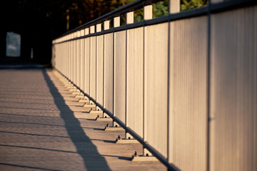 The abstract pattern of the shadows of the bridge railing on the pavement on the bridge of the Flussstrasse over the Wöhrder See in Nuremberg, Germany, in the evening light in April 2019