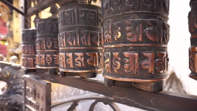 Prayer wheels rolling at Swayambhunath Stupa (Monkey Temple) in Kathmandu Nepal with the mantra Om Mani Padme Hum