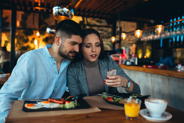 happy couple having breakfast in restaurant or food corner