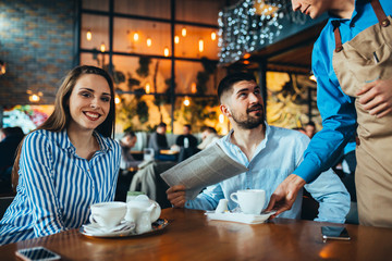 waiter serving tea in restaurant. couple drinking tea