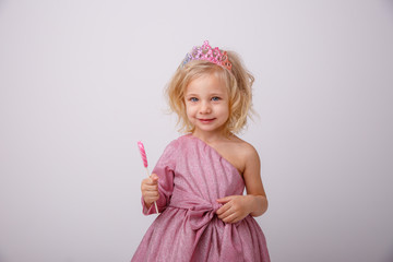 beautiful little blonde girl with a heart shaped Lollipop