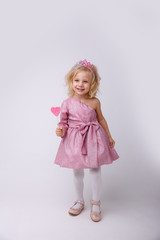 beautiful little blonde girl with a heart shaped Lollipop