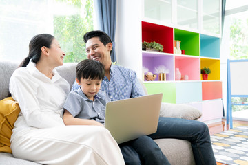 Asian family leisure and happy with computer laptop in the living room